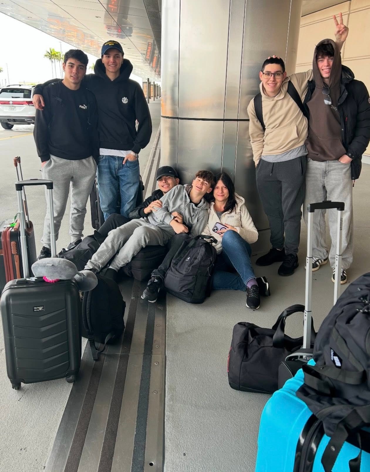 A host mother with her exchange students and their luggage at the airport