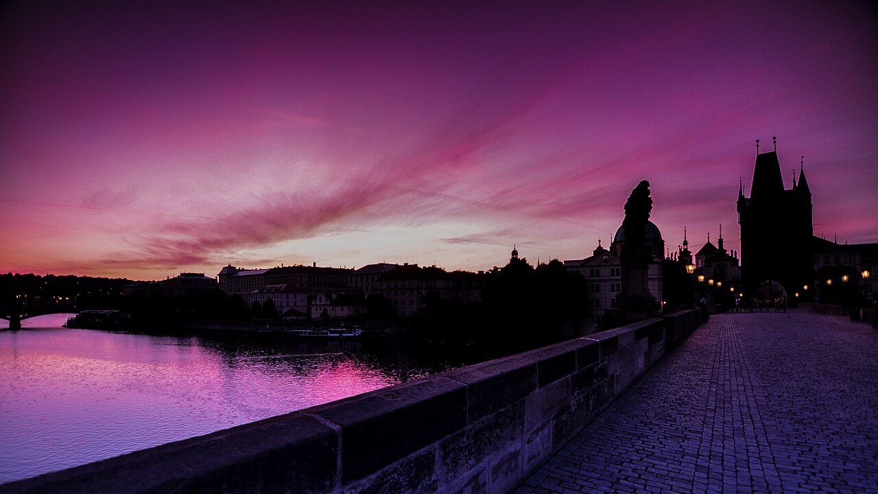 Charles Bridge in Prague at dawn under a pink and purple sky
