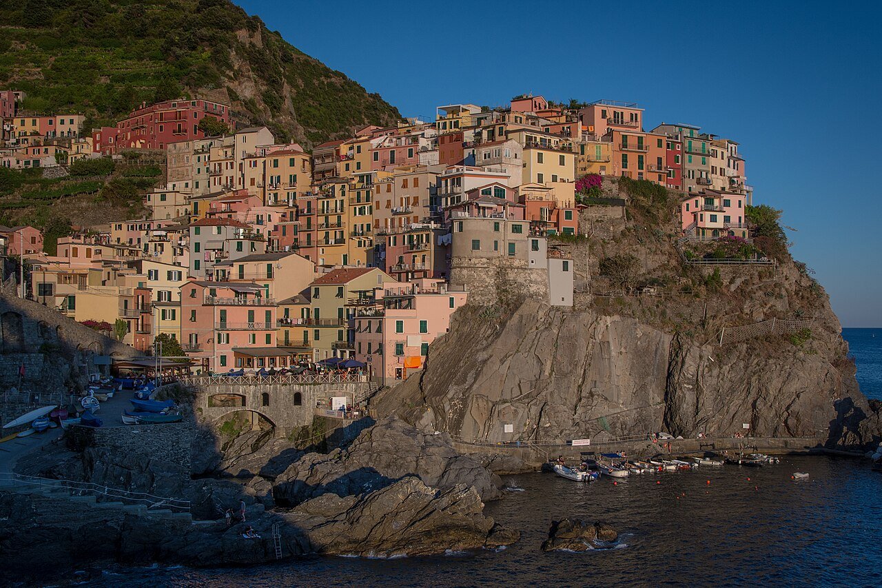 Colorful cliffside houses of Manarola in the Cinque Terre glowing before sunset