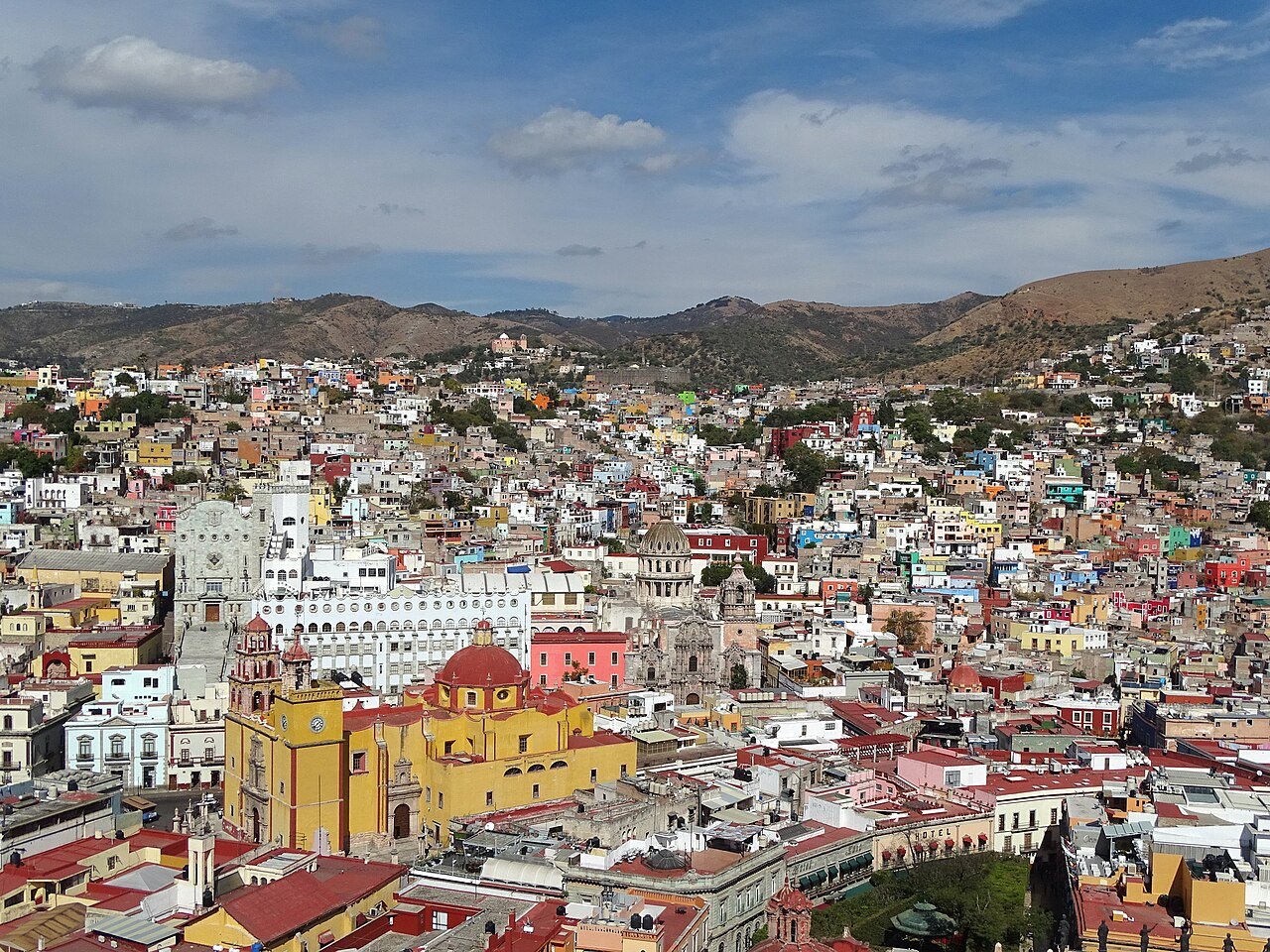 Colorful hillside houses and yellow basilica of Guanajuato seen from El Pipila