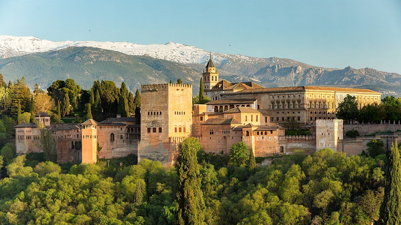 The Alhambra palace in Granada at golden hour with the snow-capped Sierra Nevada behind