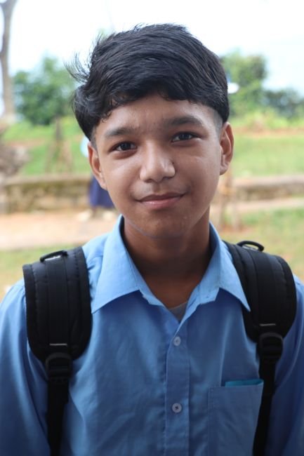 A smiling teenage boy in a school shirt